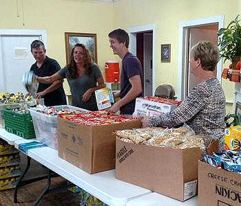 ALMS HOUSE volunteers packing bags of food for KAP.